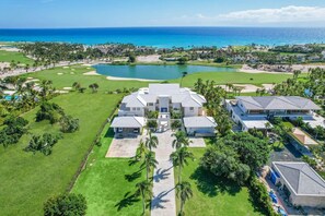 A large, modern resort with multiple buildings, a golf course, and a large body of water.