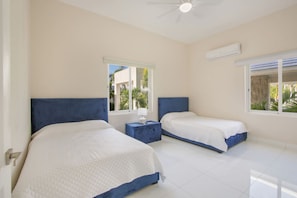 A hotel room with two beds, a ceiling fan, and large windows. - Okyanus: Spectacular oceanview estate w/ pool, Jacuzzi, full staff & golf cart (Punta Cana)