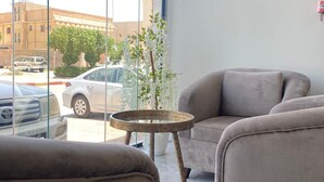 Una sala moderna con dos sofás, una mesita redonda y una planta en maceta.