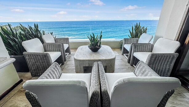 A patio with wicker furniture and a view of the ocean. - Beachfront Oasis with a View - Puerto Vallarta (Puerto Vallarta)