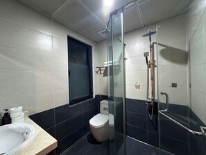 A modern bathroom with a glass-enclosed shower, a toilet, and a sink. - Luxe Paradise Residence 80 Tu Hoa (Hanoi)