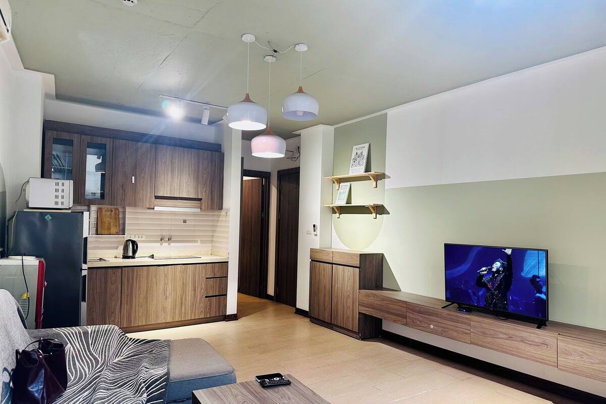 A modern living room with a sofa, a coffee table, and a flat-screen TV.