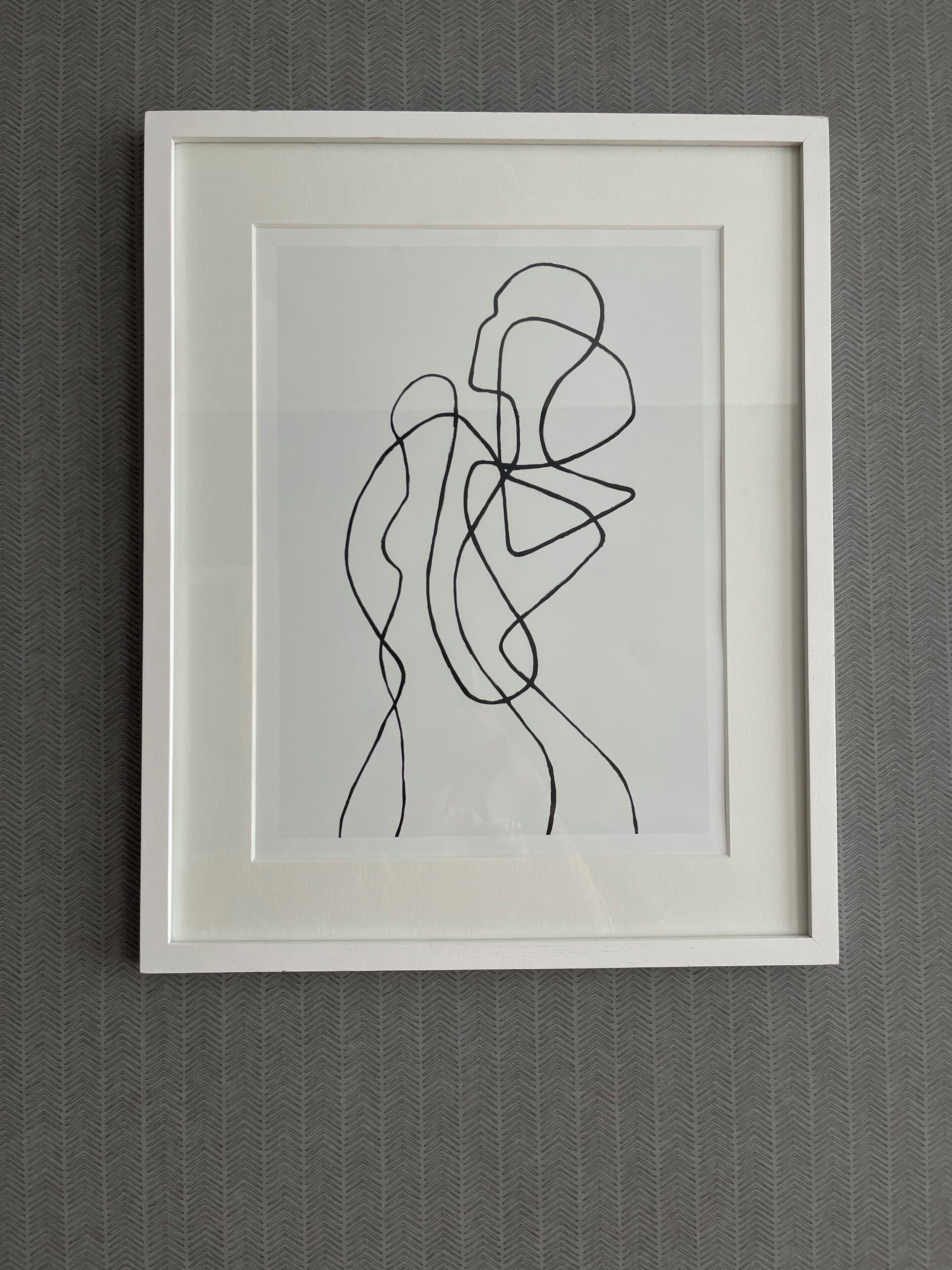 A framed abstract art piece with a simple, clean design.