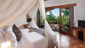 Una camera da letto con un letto a baldacchino, una televisione e vista sul giardino.