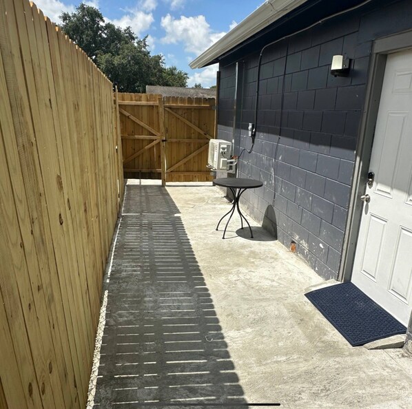 A garage with a concrete floor, a wooden fence, and a black tiled wall. - Delightful Studio 1Bed/1Bath (Orlando)