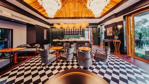 A bar area with checkered flooring, modern seating, and chandeliers. - Seclusion with the mountain (Wuhan)