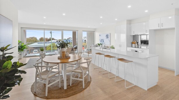 A modern kitchen with a central island, white cabinetry, and a large window offering a view of the outside. - Walk to Beach and shops, Spacious, Ocean Views (Ocean Grove)