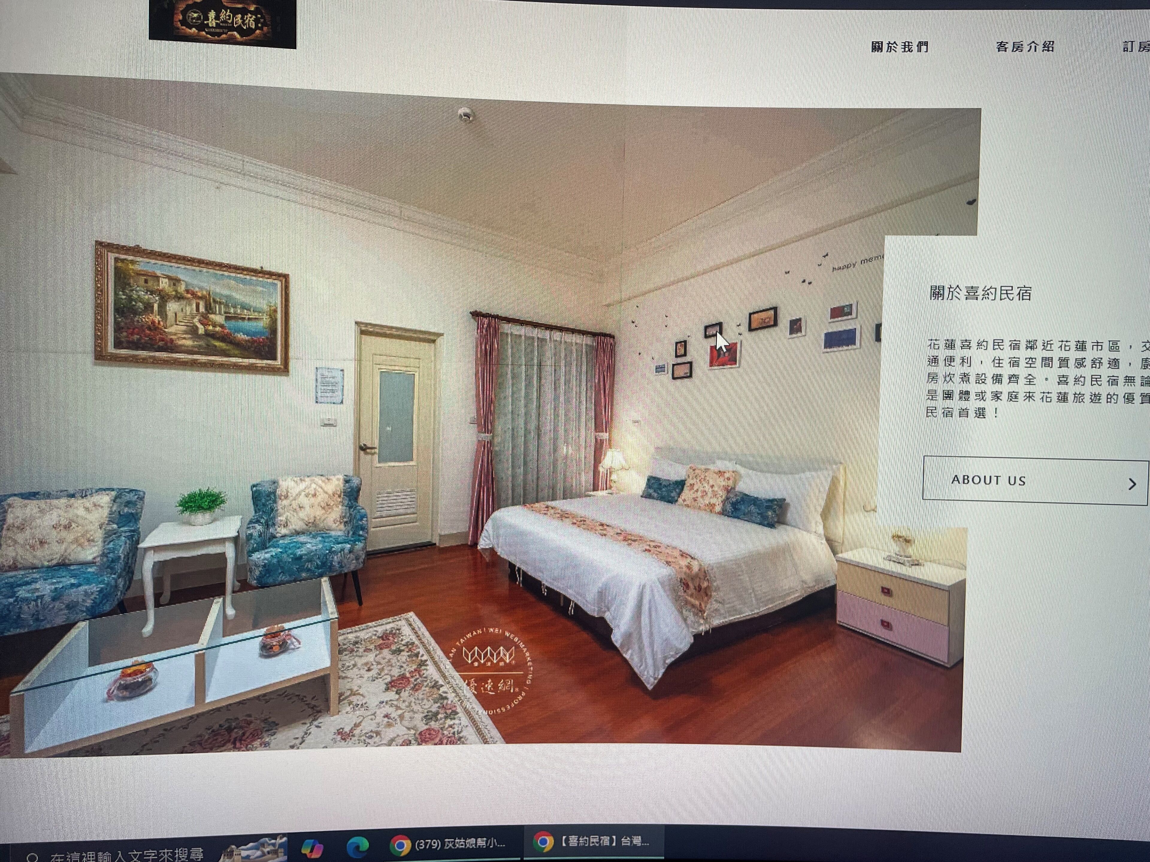 A hotel room with a bed, a sofa, a small table, and a painting on the wall.