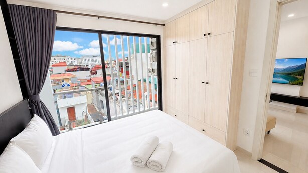 Habitación de hotel con una cama grande, un armario y una televisión.