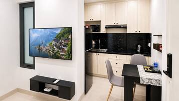 A modern kitchen with a black countertop, a built-in oven, and a microwave.