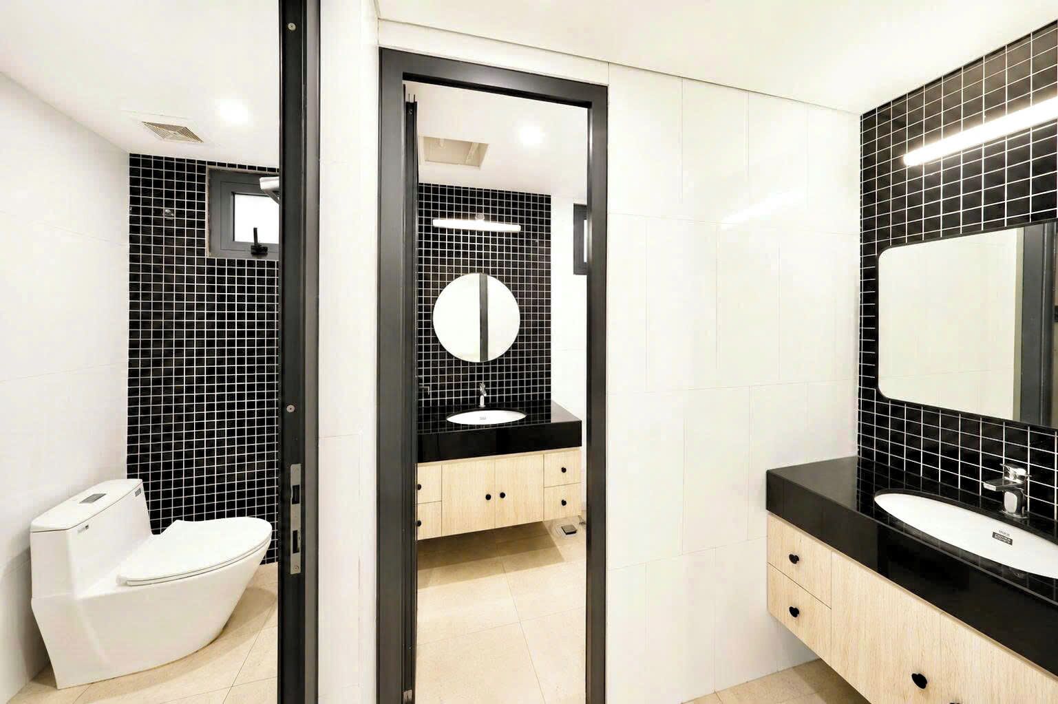 A modern bathroom with a toilet, a sink, and a mirror.