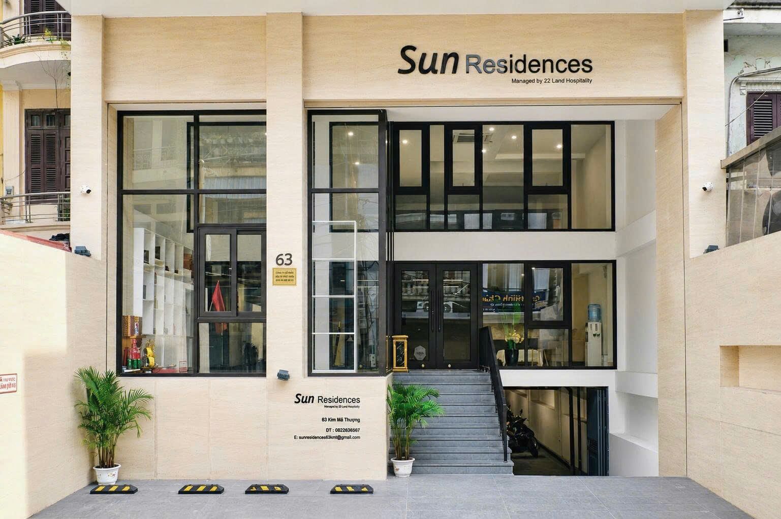 A modern building with a sign reading 'Sun Residences' managed by 22 Land Hospitality.