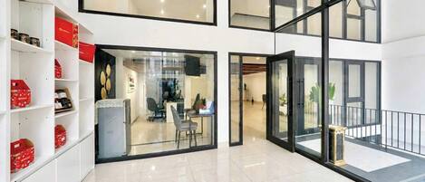 A modern interior with a reception desk, office space, and a balcony with a railing.