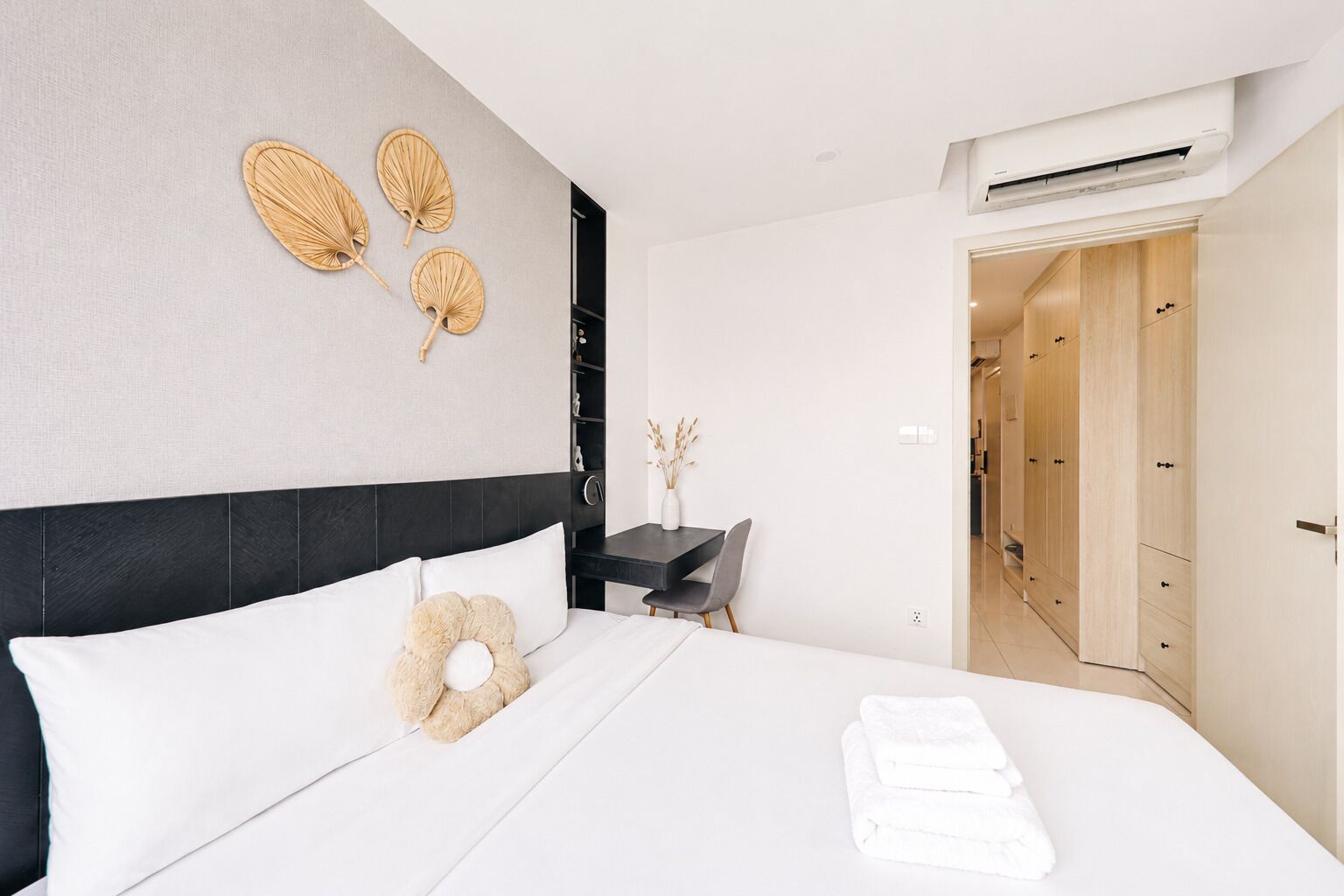 Una habitación de hotel moderna con cama, mesita de noche y escritorio con silla.