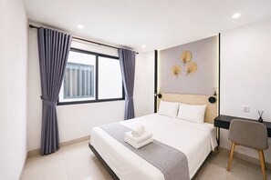 A modern hotel room with a large bed, a desk, and a window with curtains. - Sun Residences Hotel and Apartment (Hanoi)