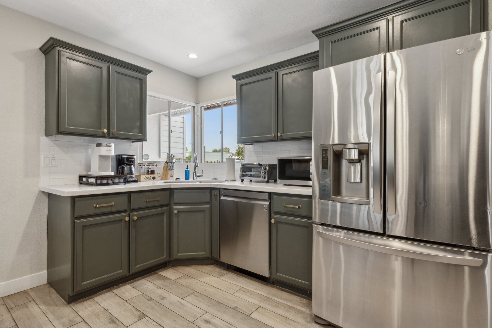 A modern kitchen with dark cabinets, stainless steel appliances, and a dishwasher.