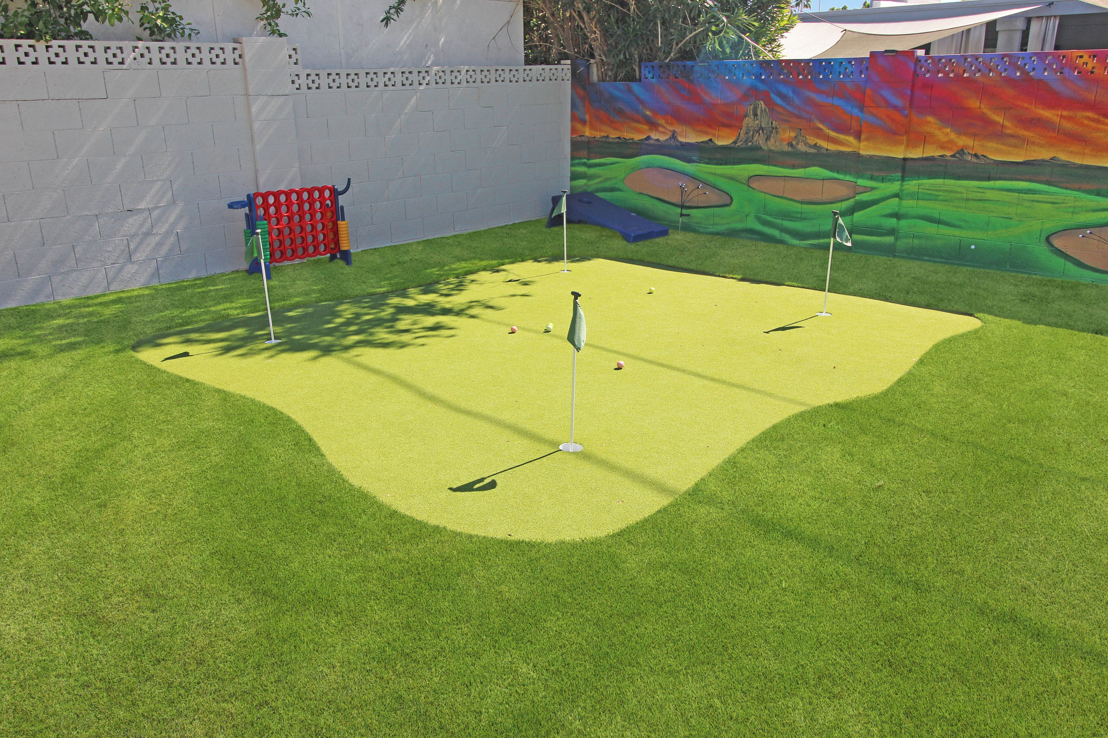 A miniature golf course with a colorful mural in the background.