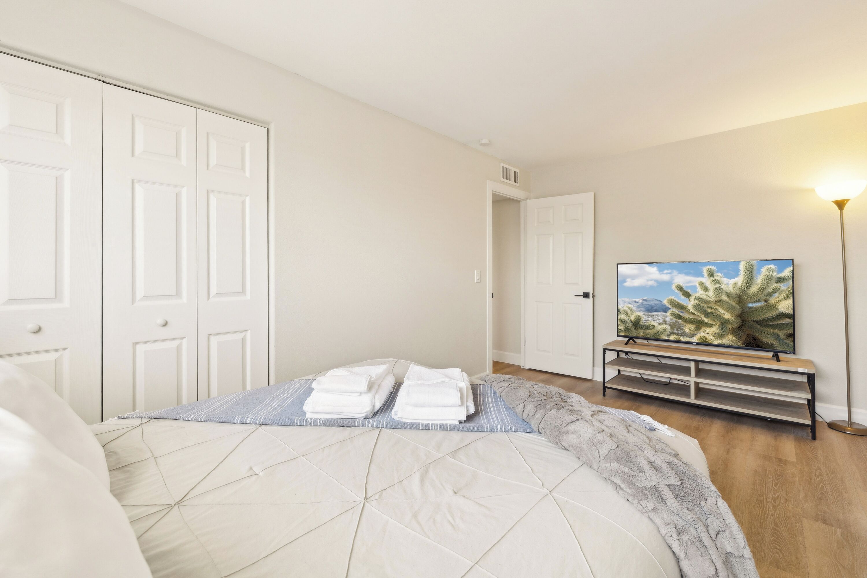A bedroom with a bed, a television, and a nightstand.