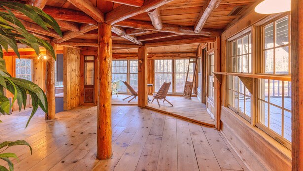 Un interior espacioso de madera con ventanas amplias y un techo alto.