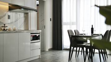 A modern kitchen with a built-in oven and a dining area with a table and chairs.