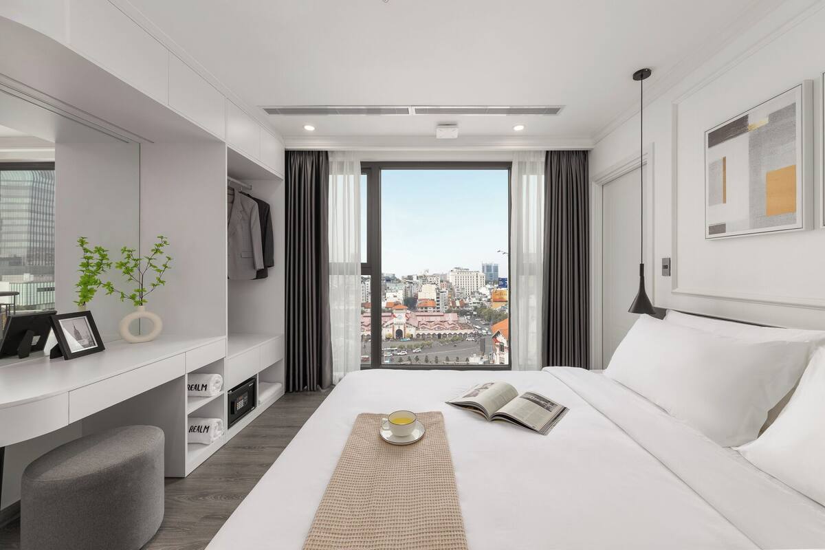 Une chambre d’hôtel moderne, équipée d’un lit, d’un bureau et offrant une vue sur la ville.