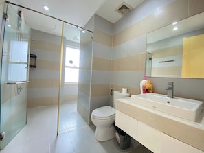 A modern bathroom with a glass shower enclosure, a toilet, and a vanity with a sink and mirror. - SUNRISE CITY VIEW Retreat (Ho Chi Minh City)