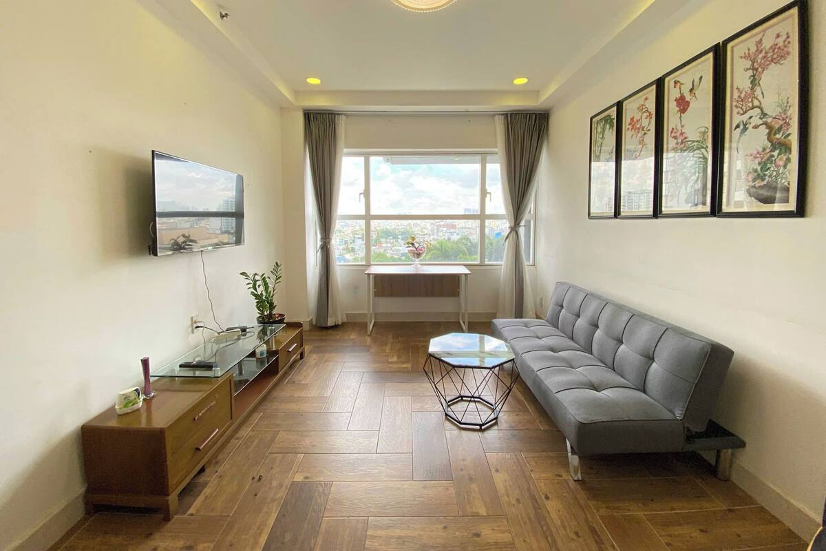 A modern living room with a sofa, a coffee table, a TV, and artwork on the walls.