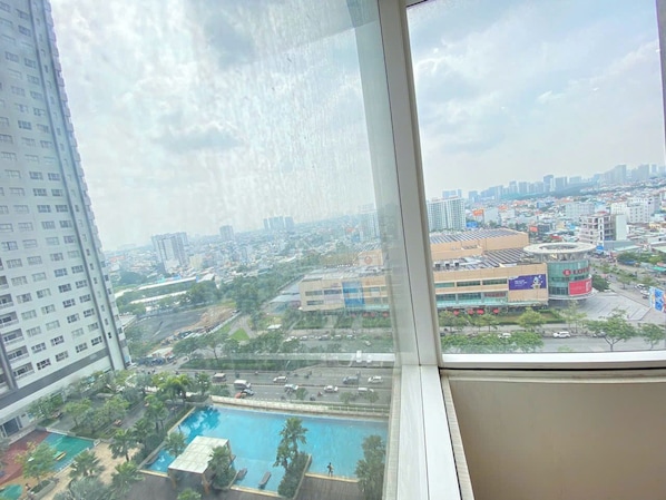 A high-rise building with a view of a cityscape, including a swimming pool and various buildings. - SUNRISE CITY VIEW Retreat (Ho Chi Minh City)