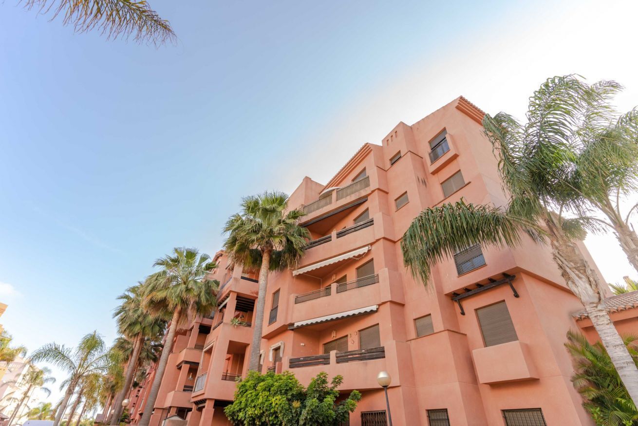A multi-story building with balconies and a flat roof.