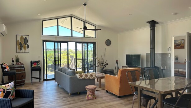 A spacious living room with a large window, a fireplace, a dining area, and a TV.