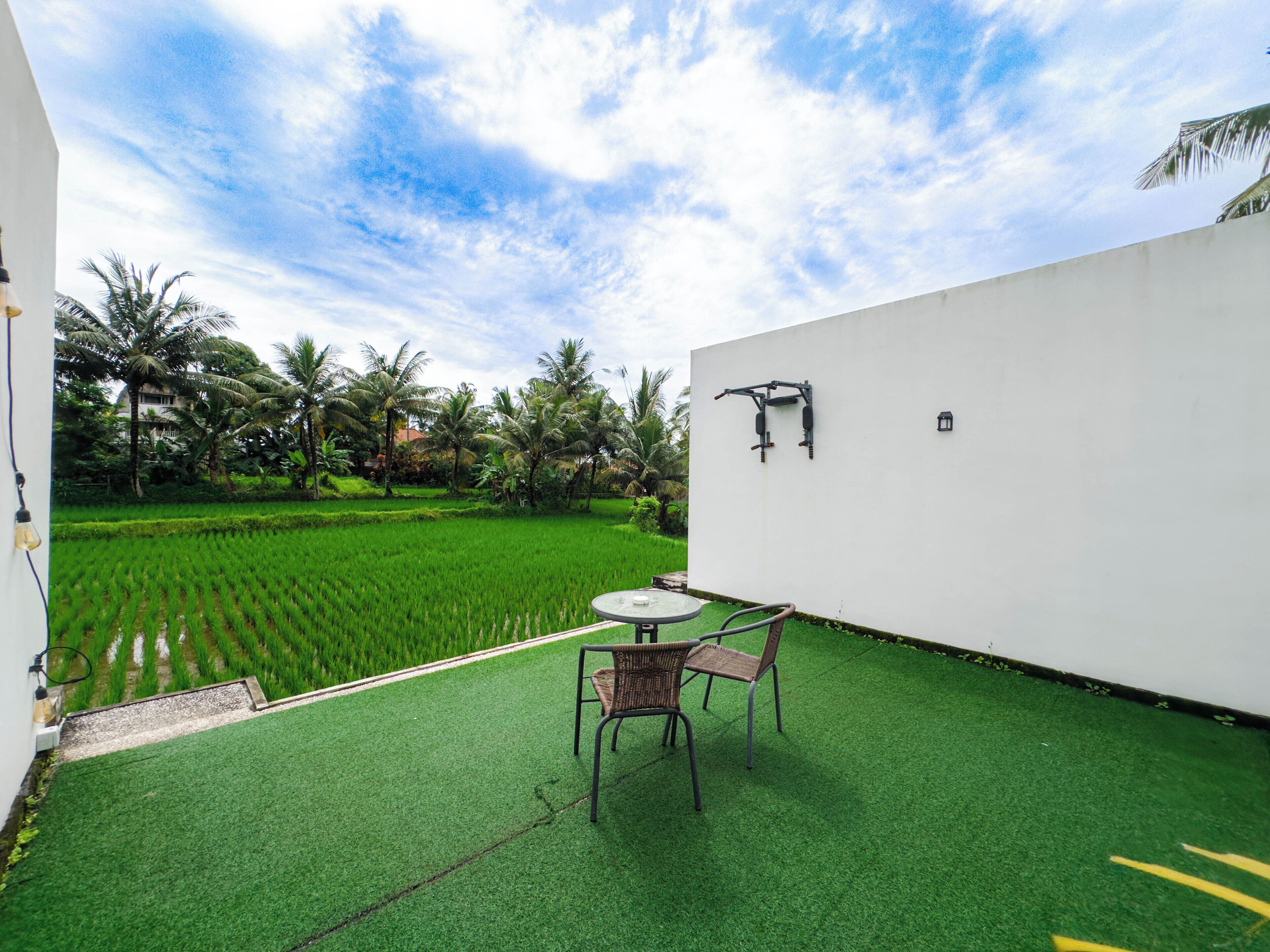 A patio with artificial grass, a table, and two chairs.