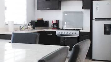 Cafetera o tetera, frigorífico, horno y placa de cocina