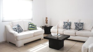 A modern living room with two white sofas, a black coffee table, and a decorative seahorse sculpture. - 3-Bedroom Pool Home · Gated Community · 3 Min to Beach · San Carlos Mexico (San Carlos)