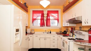 Una cucina con mobili bianchi, un fornello e un lavello.