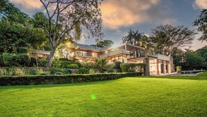 A large, modern house with multiple levels, surrounded by well-maintained lawns and trees. - House Sunbeam GuestHouse (Johannesburg)