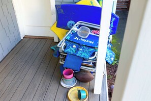 A storage area with a blue and yellow object, a metal container, a pink cup, and a brown football.