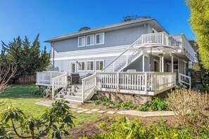 A two-story house with a covered porch and a staircase leading to the upper level. - Spacious House in Walking Distance to the Beach (Aptos)