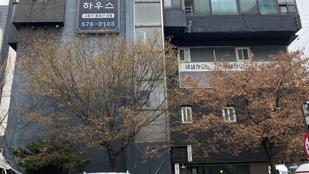 Un bâtiment moderne avec une enseigne indiquant la présence d’un restaurant et d’une entreprise.