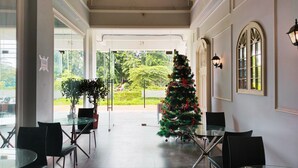 Eine Hotelhalle mit Weihnachtsbaum, Glastischen und Stühlen.