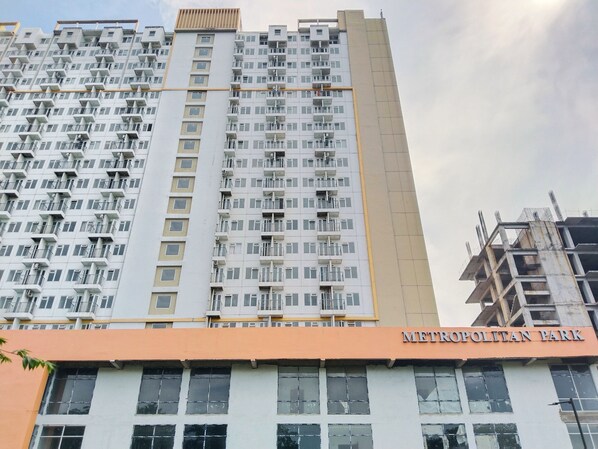 A high-rise building with multiple balconies and a sign reading "METROPOLITAN PARK". - Amerta Room Metropolitan Park powered by Cocotel (Bekasi)