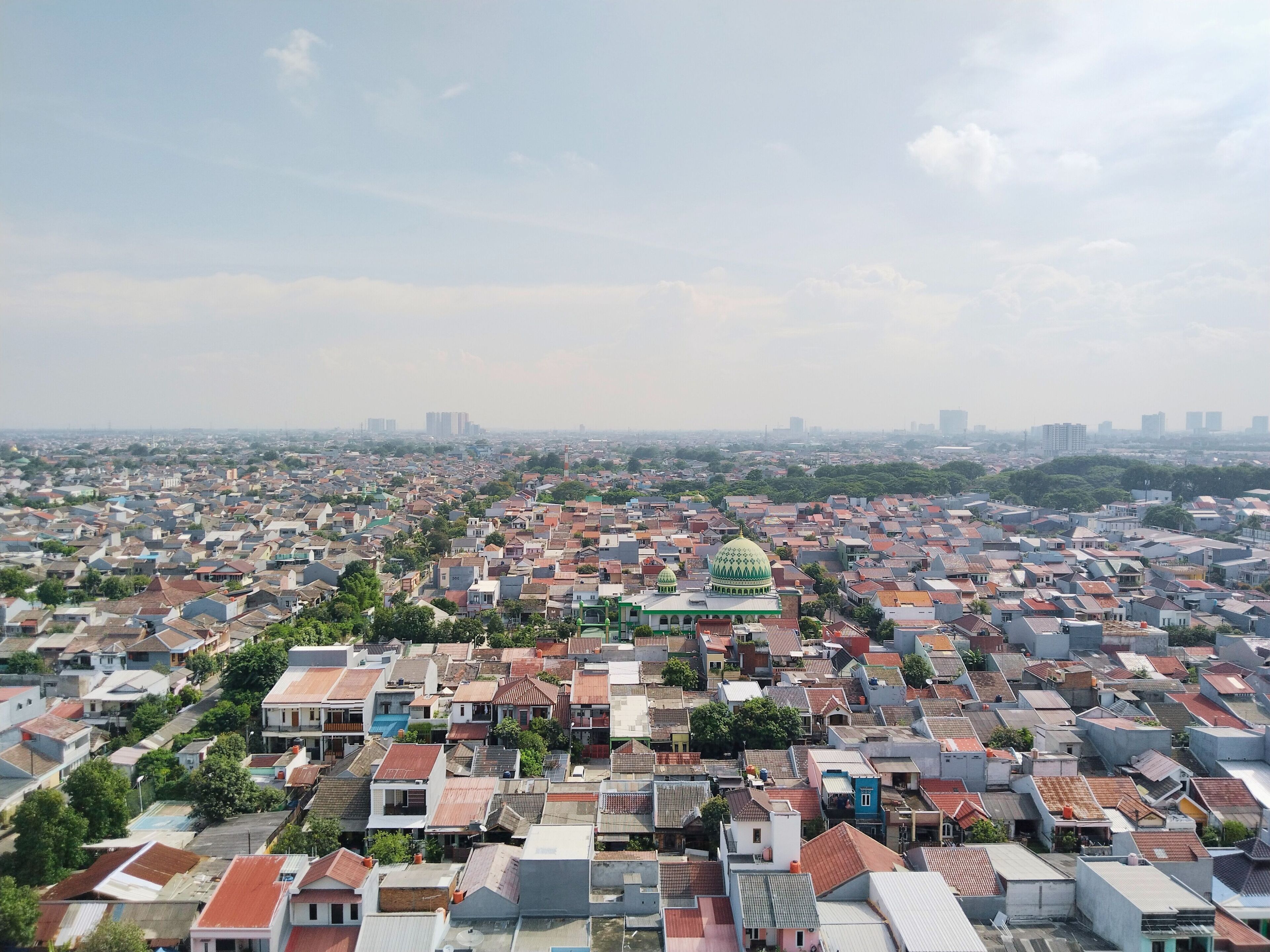 Una zona urbana densamente poblada con un edificio destacado de cúpula verde en el centro.