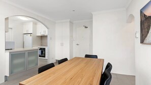 Enjoy meals in the dining area with a wooden table and black chairs, or cook in the kitchen with oven.