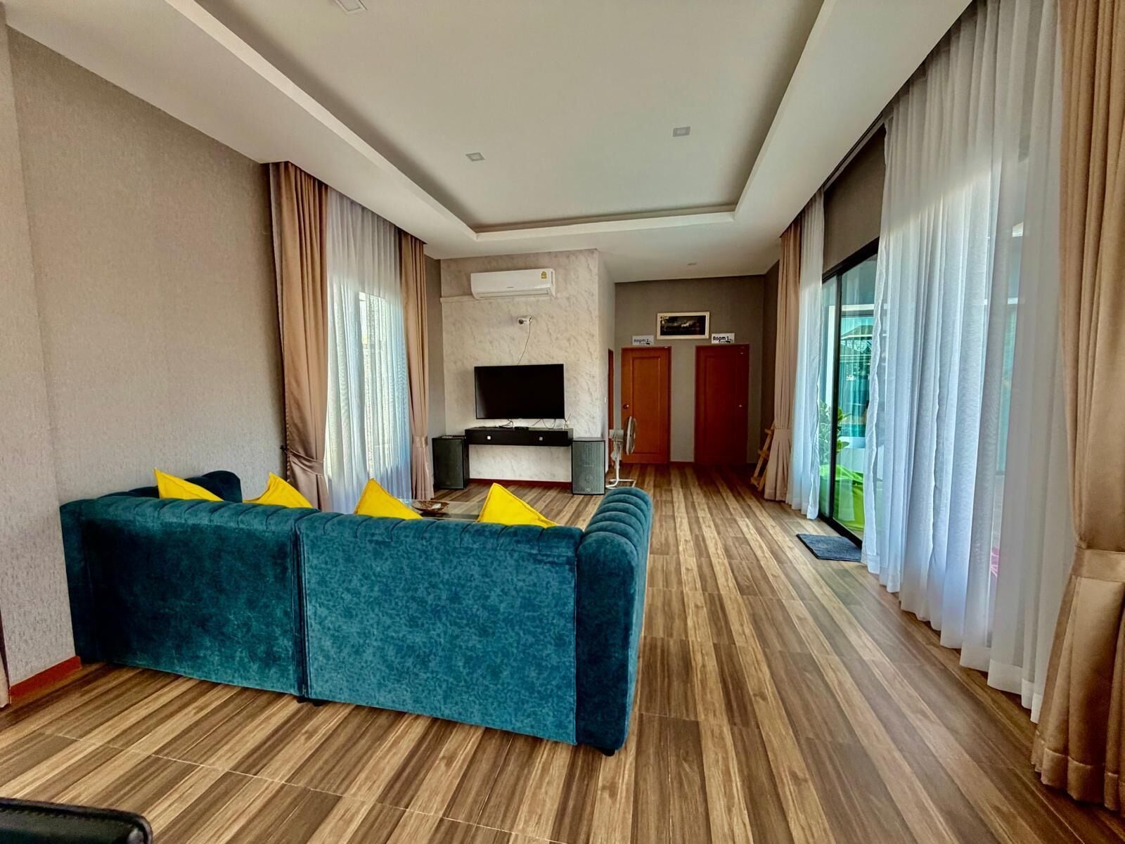 Ein modernes Wohnzimmer mit einer Couch, einem Fernseher und Holzböden.