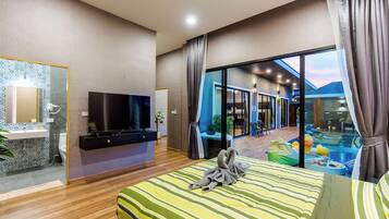 Camera d'albergo moderna con un letto grande, una televisione a schermo piatto, bagno con specchio e lavandino, e vista su piscina e area relax all'aperto.