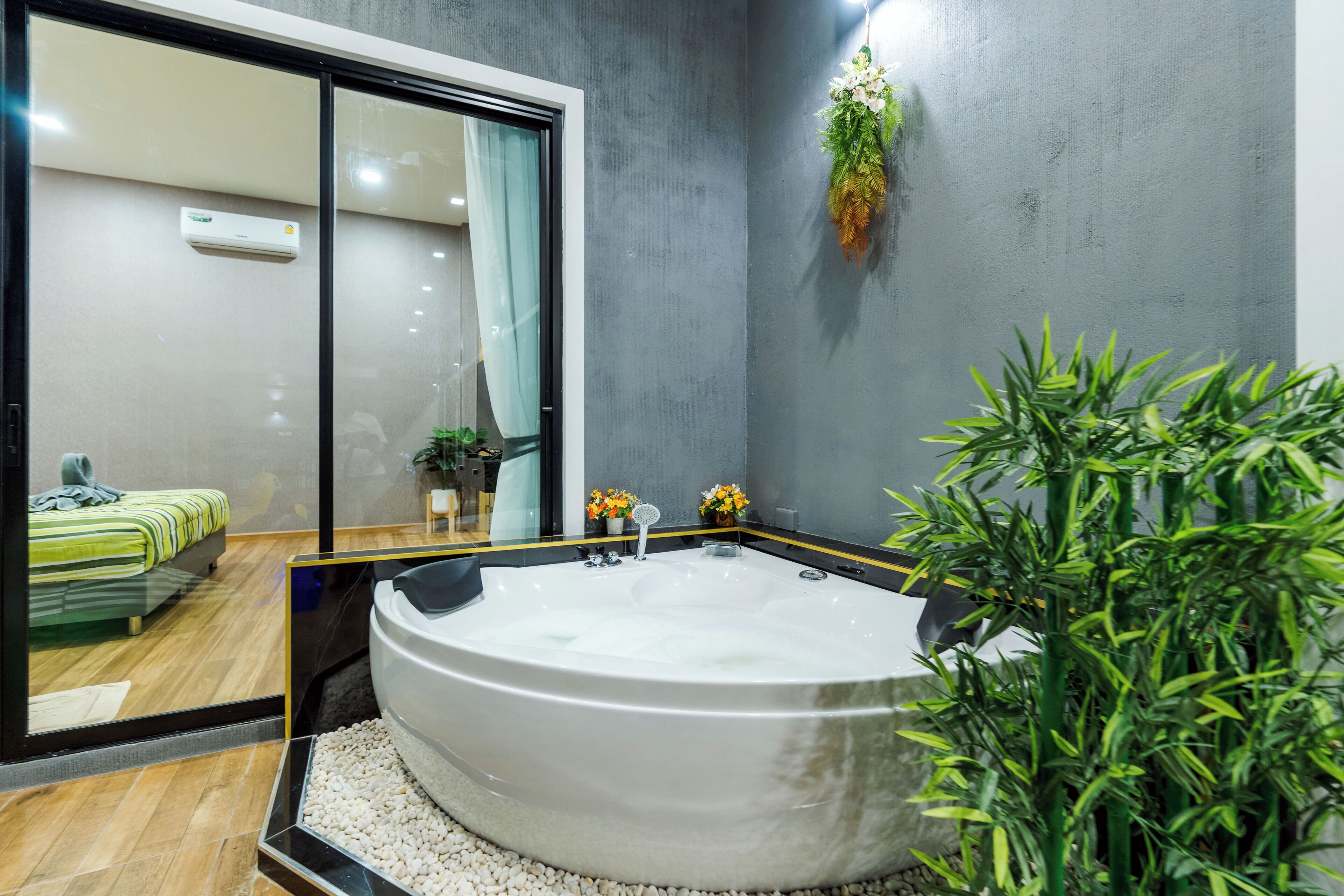 Ein modernes Badezimmer mit einer großen Badewanne, einer Duschkabine aus Glas und einem Blumentopf.