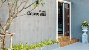 Un bâtiment moderne avec une façade en béton, une entrée en bois et une enseigne dans une langue étrangère.