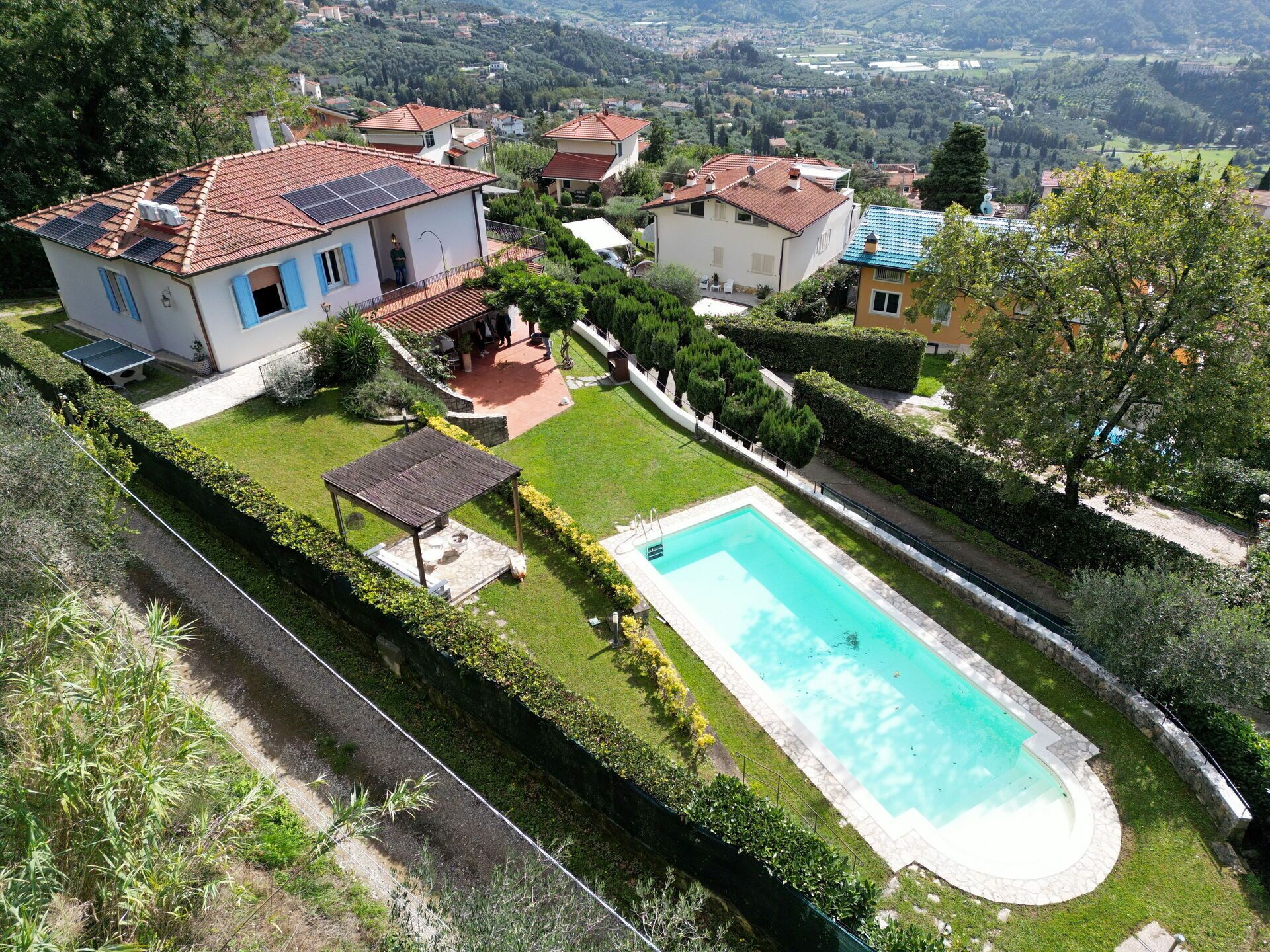 A residential property with a swimming pool, solar panels, and a well-maintained garden.