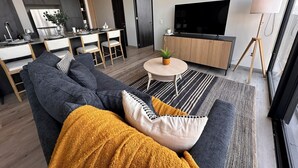 Una sala de estar moderna con un sofá, una mesa de centro y un televisor.