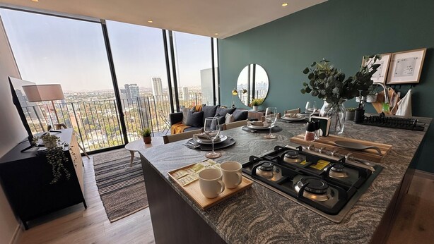 Una cocina moderna con una isla central, ventanas amplias y vistas a la ciudad.