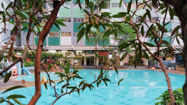 An indoor swimming pool with tiled walls and a clear blue pool. - The Royale Sentra Tower Kuning (Jakarta)